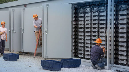 2A93W26 Engineers connecting energy storage batteries for back up power to an electric power plant