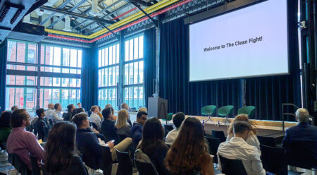 An audience watching a slide show in a large room